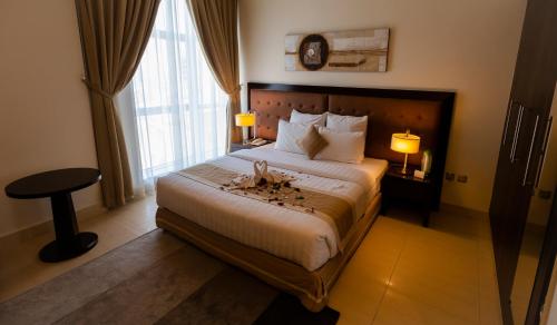 多哈帝国套房公寓的一间设有大床和窗户的酒店客房