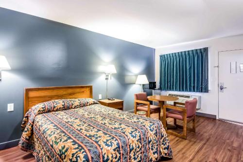里士满Rodeway Inn North Chesterfield-Richmond的酒店客房配有一张床铺和一张桌子。