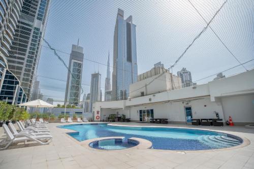 迪拜City Premiere Hotel Apartments - Dubai的一座高楼建筑中间的游泳池