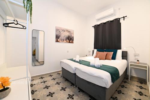 提比里亚Puy Bazelet Apartments的一间卧室配有一张大床和黑色床头板