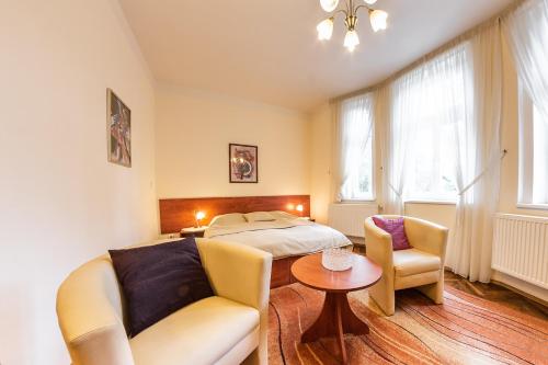 波杰布拉迪马尔卡别墅A酒店的一间卧室配有一张床、一把椅子和一张桌子