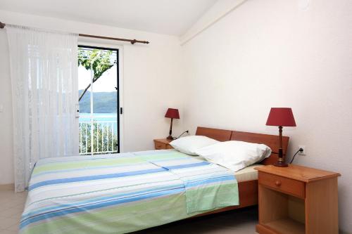 维甘Seaside apartments with a swimming pool Viganj, Peljesac - 260的一间卧室设有一张床和一个大窗户