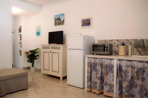 马丁纳弗兰卡Casa Vacanze L'essenziale的厨房配有冰箱和微波炉。