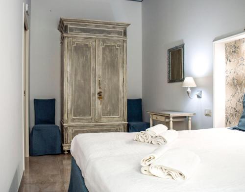 马丁纳弗兰卡Casa Vacanze L'essenziale的一间卧室配有一张床和两张蓝色椅子