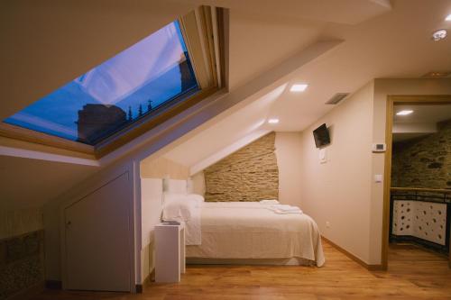 圣地亚哥－德孔波斯特拉豪斯佩德里亚特莱雅旅馆的一间卧室设有一张大床和大窗户