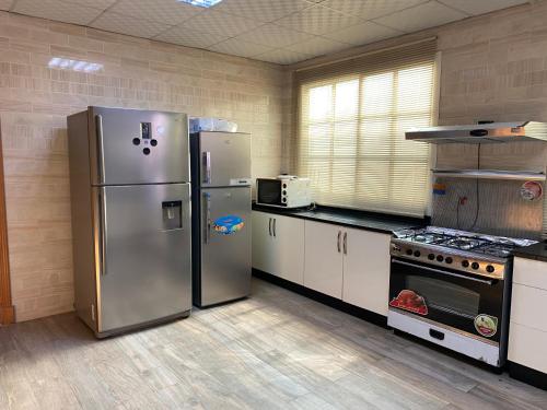 沙迦Holiday Home Rent villa的厨房配有2台不锈钢冰箱和炉灶