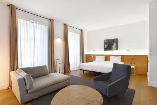 布达佩斯布达佩斯泽尼特皇宫酒店的酒店客房配有床、沙发和椅子