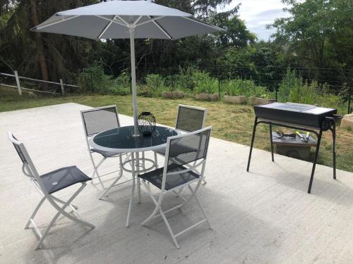 日安villa skys France的庭院里配有桌椅和遮阳伞