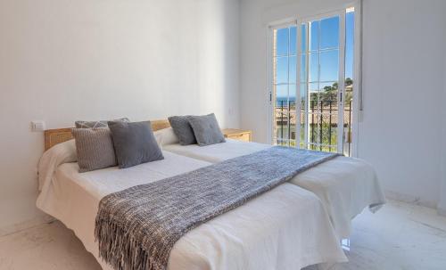 拉海瑞德拉Blue Luxury Apartment的一间卧室设有两张床和大窗户