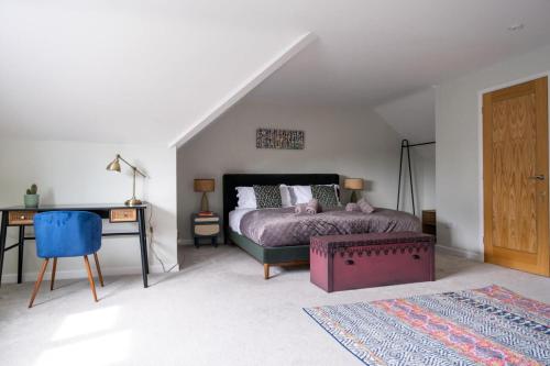 灵伍德Tree Top House的一间卧室配有一张床、一张桌子和一张四柱床。