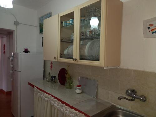 希马拉Vila Gjoka的厨房配有水槽和装满碗碟的橱柜