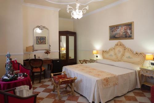 巴勒莫Hotel Trinacria的一间卧室配有一张床、一张桌子和一面镜子