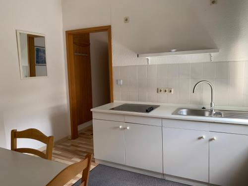 杜伊斯堡弗赖哈芬酒店的厨房配有白色橱柜、水槽和桌子