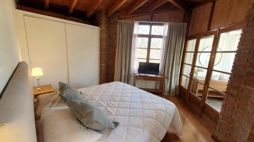 查克拉斯德科里亚La Bignonia Posada的卧室配有白色的床和窗户。
