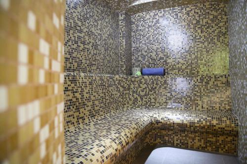 锡纳亚斜森林spa旅馆的浴室设有步入式淋浴和棕色瓷砖