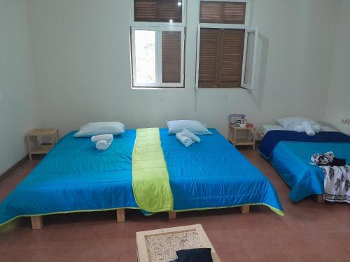 CaculiPousada Rural Simpatia的配有两张床铺的客房提供蓝色的床单和毛巾