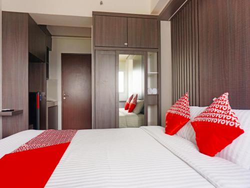 ParungdengdekOYO 91593 San San Rooms Apartment Gunung Putri Square的一间卧室配有一张大床和红色枕头