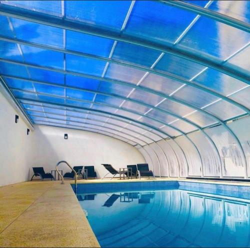 内科切阿Departamentos Casa del Parque的一座拥有蓝色天花板的室内游泳池