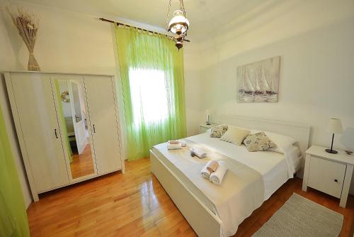 科尔丘拉Apartments by the sea Korcula - 549的一间卧室配有一张带白色床单的床和一扇窗户。