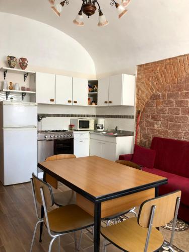 CandeloLa Taverna del Ricetto的厨房以及带桌椅的起居室。