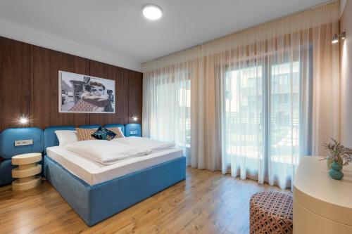 布达佩斯The Magazine Rooms的一间卧室设有蓝色的床和大窗户