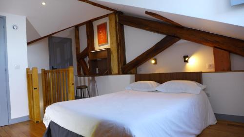 凡尔赛莱斯凡尔赛住宿加早餐旅馆的卧室配有一张带木梁的白色大床