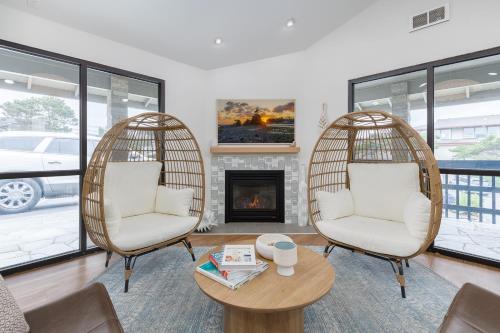 林肯市Surfland Hotel的带壁炉的客厅配有两把椅子和一张桌子