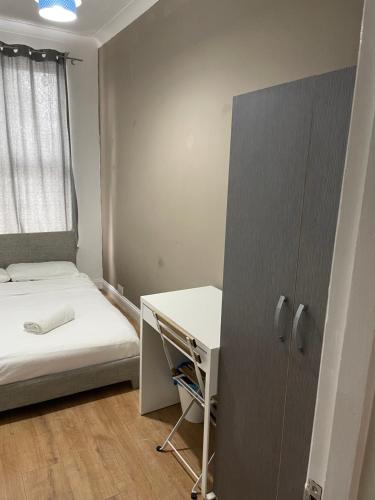 伦敦03 Bedroom Apartment-Self Check in的小房间设有一张床和一张书桌