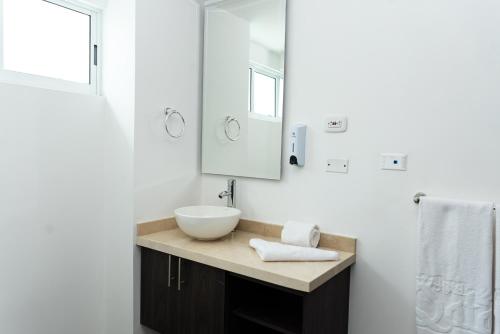 卡利Hotel Qatar Cali的白色的浴室设有水槽和镜子