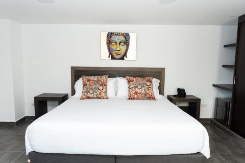 卡利Hotel Qatar Cali的卧室配有一张带两张桌子的大型白色床
