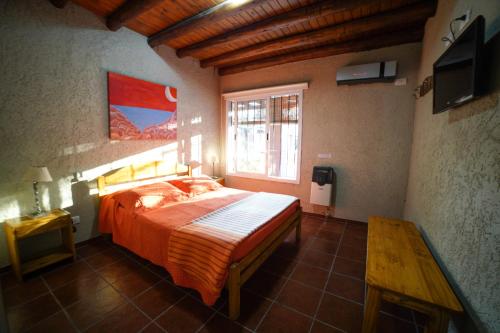 卢汉德库约Cabañas Parque Vistalba的一间卧室设有一张大床和一个窗户。