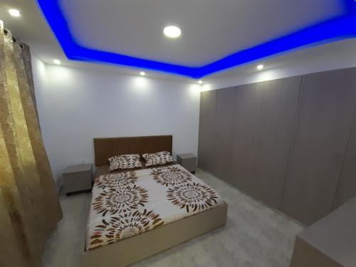 哈马马特Dar salah的一间卧室配有一张蓝色天花板的床
