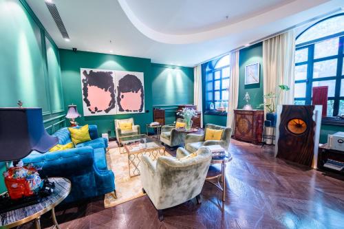 北京格瑞斯艺术酒店的客厅配有蓝色的沙发和椅子