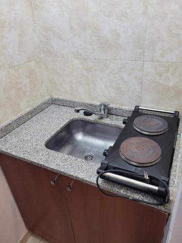 圣米格尔·德·图库玛Departamento Calle San Martin ( Microcentro)的厨房柜台配有炉灶和水槽