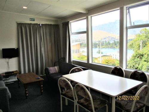 皇后镇Spectacular Lake & Mountain Views的带沙发、桌子和窗户的客厅