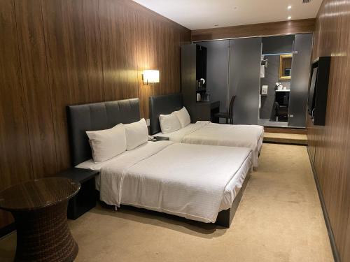 台北水滴米窝的酒店客房设有两张床和一张桌子。