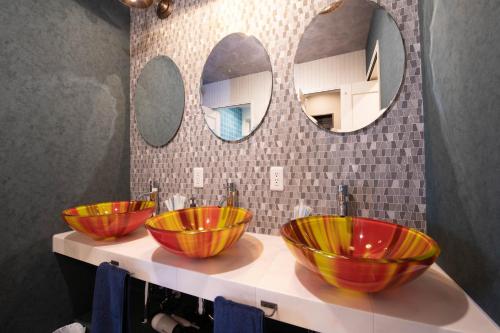 小樽THE BEEHIVE AIOI的带两面镜子的浴室的柜台上放了三个碗
