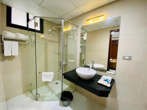 太原省金泰酒店的一间带水槽和玻璃淋浴的浴室