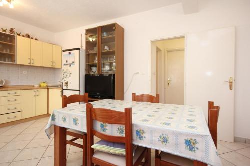 维甘Apartment Viganj 633c的厨房配有桌椅和冰箱。