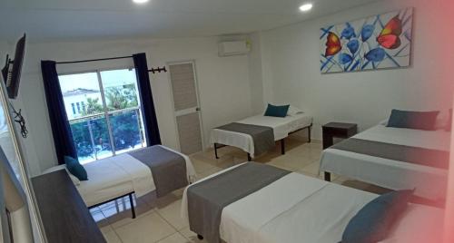 SoledadHotel La Inmaculada的酒店客房设有两张床和窗户。