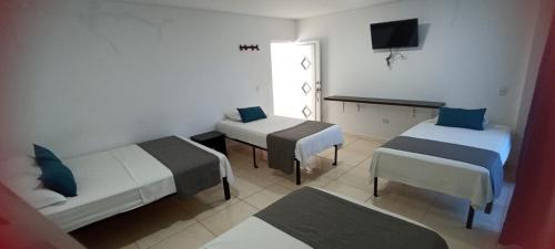 SoledadHotel La Inmaculada的酒店客房设有两张床和电视。