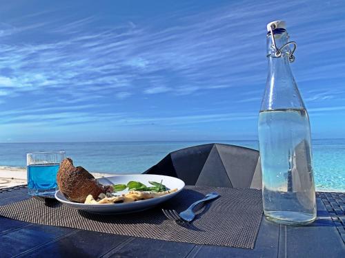GaafaruNiru Isle Maldives的一张桌子,上面放着一盘食物和一瓶水