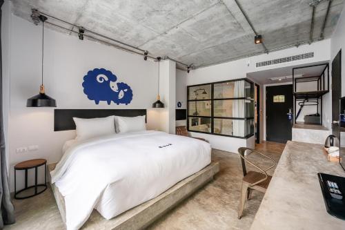 蔻立Kokotel Khao Lak Lighthouse - SHA Extra Plus的一间卧室配有一张大床,墙上挂着蓝色标志