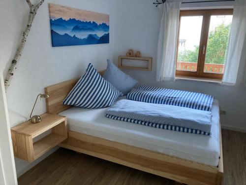 希格斯多夫TraunZeit的一间卧室配有带两个枕头的床和窗户