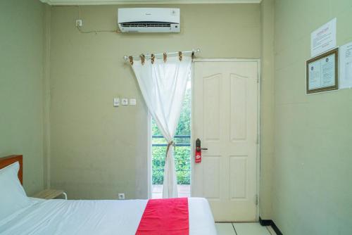 BojonegoroRedDoorz Plus Syariah At Lotus Hotel Bojonegoro的一间卧室设有一张床和一个窗口