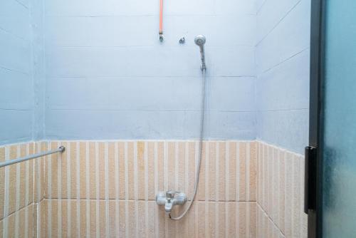 BojonegoroRedDoorz Plus Syariah At Lotus Hotel Bojonegoro的浴室内带软管的淋浴