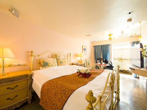 神户V酒店（仅限成人）的一间卧室配有一张带鲜花的大床