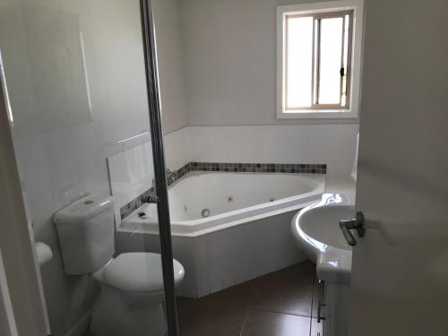 因沃洛什因沃洛什小木屋及公寓式酒店的白色的浴室设有浴缸和卫生间。