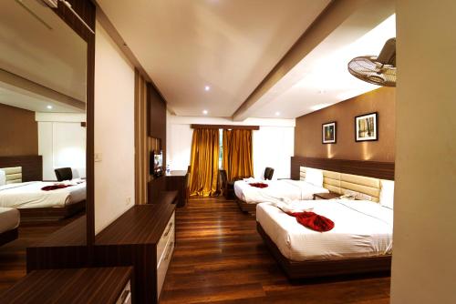 科泽科德Emarald Hotel Calicut的一间酒店客房,房间内设有三张床