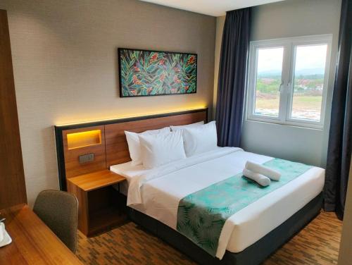 新山NB HOTEL的一间卧室设有一张大床和窗户